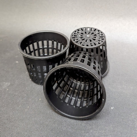 Three black plastic net pots used for growing plants